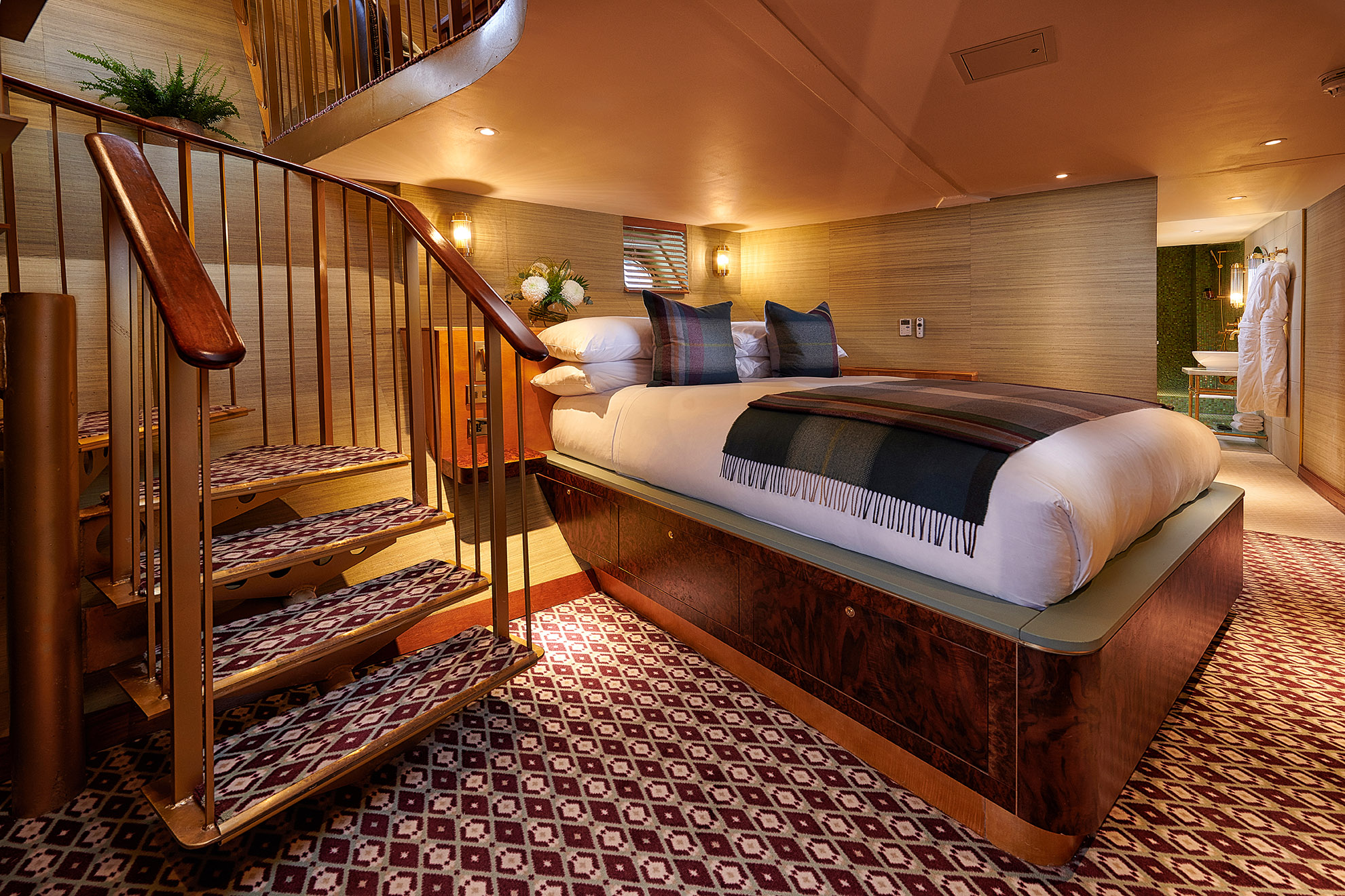 A hotel room featuring a double bed and a staircase.